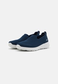 Blaue Mesh-Slipper mit einer strukturierten Oberseite, weißer Gummisohle und Zugschlaufe an der Ferse für ein einfaches An- und Ausziehen. Leicht und atmungsaktiv.