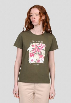 T-shirt en coton vert olive à manches courtes. Présente un motif floral en rose, blanc et vert. Texte "LES FLEURS" au-dessus du design.