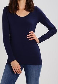 Mörkblå långärmad topp med scooped halsringning och slim fit; tillverkad av mjukt, stretchigt material med en subtil logodetalj på bröstet.