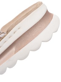 Sectie van een beige en metallic roségouden schoenzool met een dikke witte rubberen buitenzool met geschulpte rand en een getextureerde gripband.