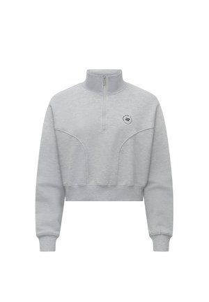 Ljust grå kort sweatshirt med hög krage, halvdragkedja fram och subtila sömdetaljer. Har en liten logotyp på bröstet.