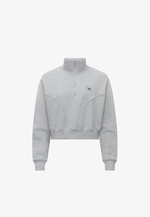 Light gray cropped sweatshirt with a high collar, half-zip front, and subtle stitching detail. Features a small logo on the chest.
