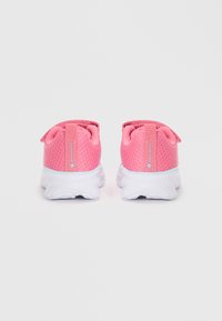 Roosad õhku läbilaskva võrkkattega spordijalatsid valgete talladega, nähtud tagant jahedal heledal taustal.