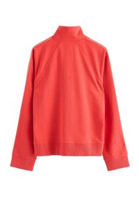 Felpa rossa con collo alto, polsini e orlo a costine, e strisce a contrasto lungo le spalle. Tessuto morbido e strutturato.