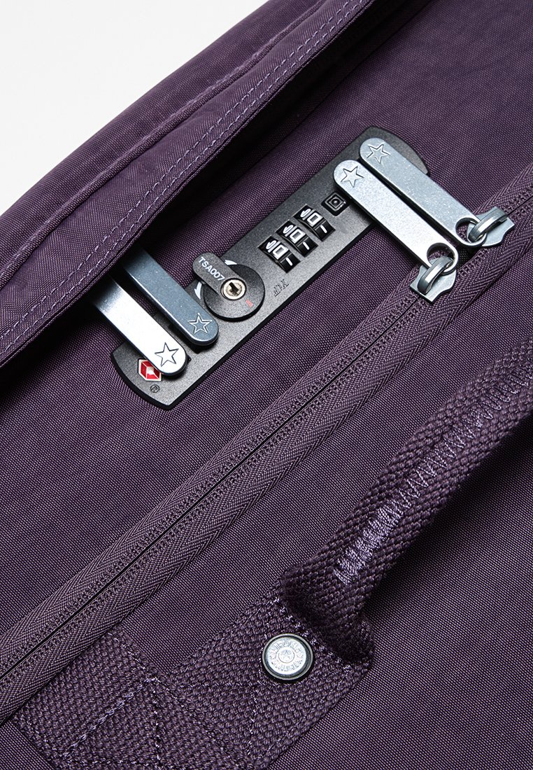 Borsa in tessuto viola con chiusura a zip metallica dotata di combinazione, manici robusti e dettagli texture vicino alla zip.