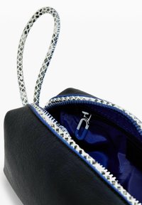 Black leather pouch with a white and navy patterned zipper. Interior features navy fabric with a silver clip visible inside.