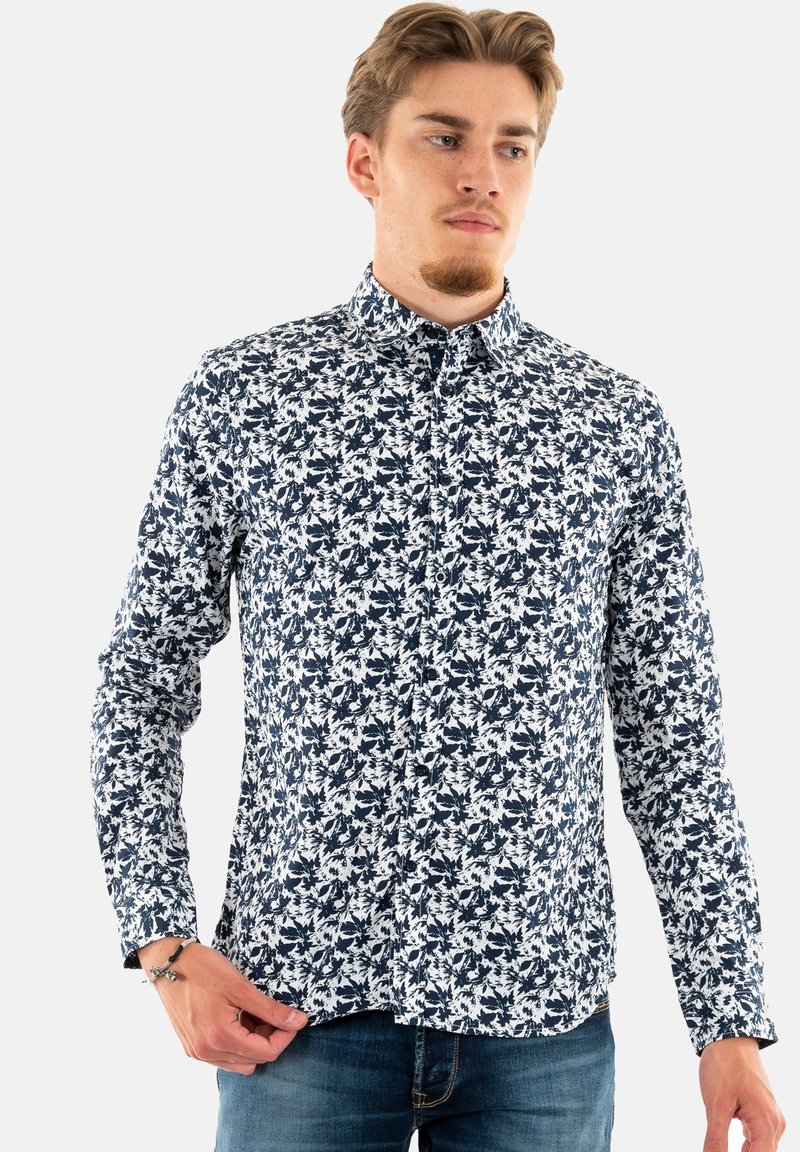 Langarmshirt in wit en marineblauw, met een bloemmotief. Geknoopte kraag, getailleerd ontwerp en textuurstof. Effen manchetten en zoom.