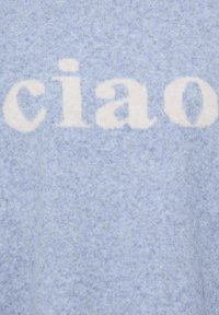 Tissu bleu doux avec le mot "ciao" tricoté en grandes lettres minuscules blanches dessus.