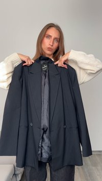 Musta viiruinen bleiseri, jossa on leveä kaulus, kaksi nappia ja satiinin sisustus. Yhdistettynä kermanväriseen neulotakseen.