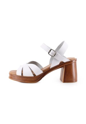 Sandalia de cuero blanco con punta abierta, correa ajustable en el tobillo, suela de plataforma de madera y tacón grueso de bloque.