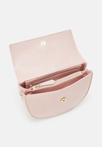 Ljusrosa handväska med glansigt ytskikt, utrustad med ett guldigt tryckknäppningslås och ett inre ficka med dragkedja. Stor huvudfack med kortplatser.