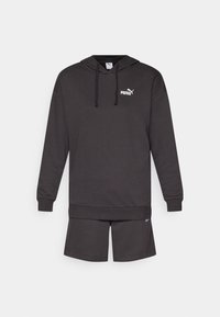 Donkergrijze hoodie met een kangoeroezak, verstelbare trekkoordkap, en een wit Puma-logo. Gecombineerd met bijpassende shorts met logo-accenten.