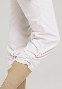 Jasnoróżowe, krótkie spodnie z gathered cuffs, miękkim wykończeniem i subtelnymi pionowymi paskami dla dopasowanego, eleganckiego wyglądu.