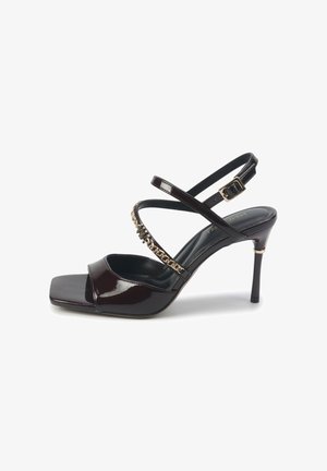 Tamsiai bordo lakuoti aukštakulniai šlepetės su kvadratiniu priekiu, plonomis kryžminėmis juostelėmis, auksinės grandinėlės akcentu ir grakščiu stiletto kulnu.