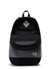 Mochila de tela gris con acentos negros, cierre de cremallera, bolsillo interno de malla y una etiqueta en forma de diamante que presenta el logotipo de la marca.
