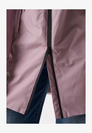 Close-up of a partially zipped mauve jacket showing black zipper and blue denim jeans underneath.