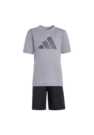 Lyse lilla T-shirt med korte ærmer og en mørkegrå Adidas-logo sammen med sorte knælange shorts på en hvid baggrund.