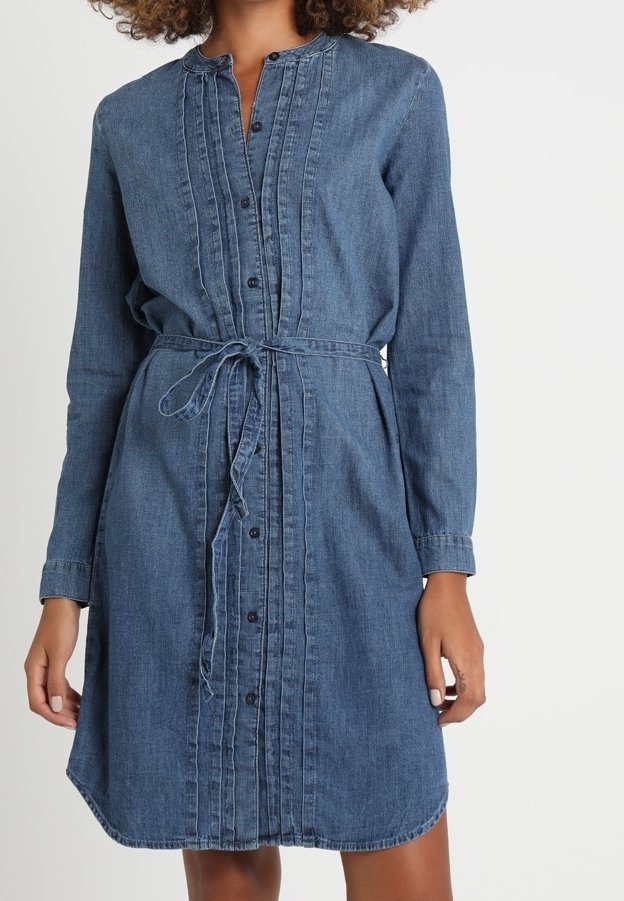 Jeansklänning med långa ärmar, knapplåst fram, plisserade detaljer och knytmidja. Färgen är mörkblå med en slät textur.