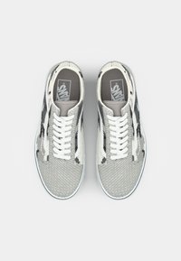 Sneakers with a mesh grey upper featuring a black and white pattern, white laces, and a grey insole with the Vans logo.丸