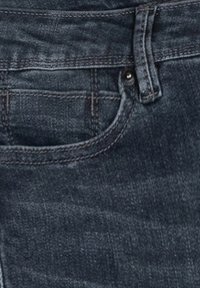 Mörkdenimjeans med en framficka, bältesöglor och en metallknapp som stängning. Tyget har en strukturerad yta med synliga sömmar.