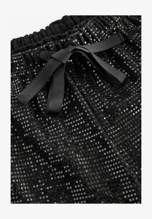Pantaloni neri con paillettes, dotati di una cintura elastica e un legaccio nero. La superficie presenta un motivo testurizzato di paillettes rotonde.