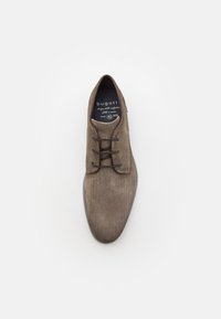 Scarpa beige con lacci a motivo, superficie testurizzata, punta arrotondata e accenti marroni a contrasto attorno all'apertura e ai lacci.