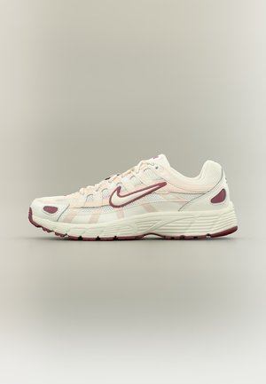 Pantof de alergare Nike alb și bordo cu panouri de plasă, design cu șireturi și talpă amortizată, afișat pe un fundal neutru.