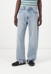 Light blue denim jeans with a loose fit, high waist, and straight legs. Features classic five-pocket design and stitched detailing.