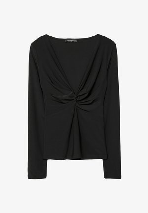 Schwarzes Langarmoberteil aus glattem Stoff mit einem verdrehten Frontdetail und einem tiefen V-Ausschnitt. Figurbetonte Silhouette mit minimalen Nähten.