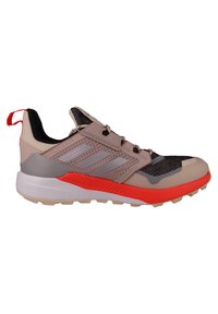Running shoes with a mesh upper in beige and black, red accents, a chunky white sole, and a textured outsole for grip.
