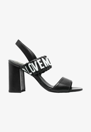 Sandal con tacco a blocco nera. Presenta una tomaia liscia, punta aperta e una fascia elastica con la scritta "LOVE" in bianco.