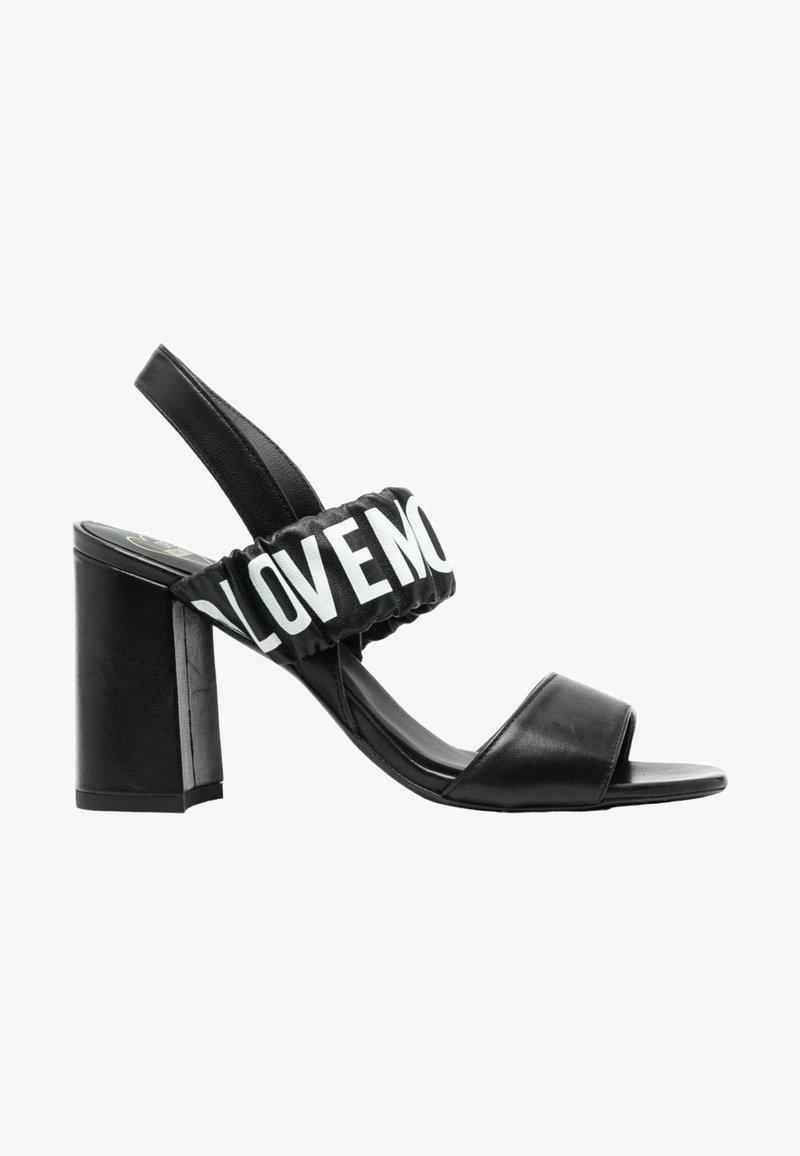 Sandal con tacco a blocco nera. Presenta una tomaia liscia, punta aperta e una fascia elastica con la scritta "LOVE" in bianco.