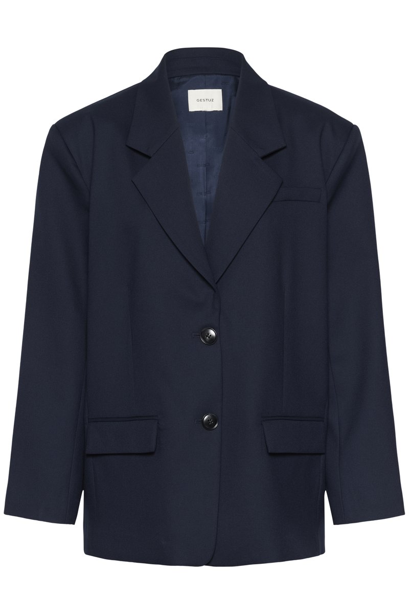 Veste bleu marine foncé à deux boutons noirs, col à revers cranté, poches à rabat et une poche poitrine passepoilée, présentée sur un fond uni.