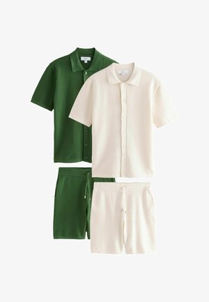 Két rövid ujjú, gombos kötött póló és hozzáillő zsinóros rövidnadrág zöld és törtfehér színben, fehér háttéren elhelyezve.