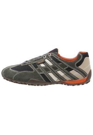 Gray suede sneaker with mesh detailing, white side stripes, orange accents, and a rubber sole featuring textured tread for grip.