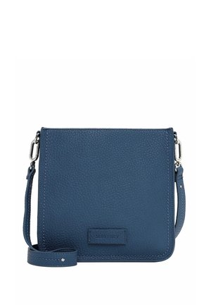 Blauwe leren crossbodytas met een geribbeld textuur, voorzien van een afneembare schouderband en een klein logo-opdruk aan de voorkant. Rechteckige vorm.