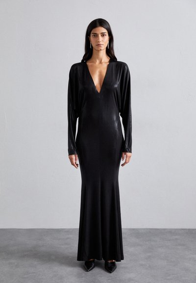 Robe noire à manches longues avec un décolleté en V profond, design long jusqu'au sol, réalisée dans un tissu lisse et brillant, présentant une silhouette ajustée.