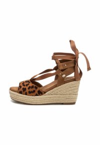 Sandalias de cuña marrones con parte superior de ante de estampado de leopardo, tiras entrecruzadas y lazos de cinta. La plataforma envuelta en yute añade textura y altura.
