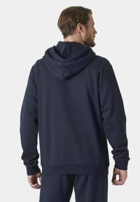 Navyblauwe hoodie gemaakt van zachte stof, met een ontspannen pasvorm, ribgebreide manchetten en een kangoeroezak aan de voorkant.