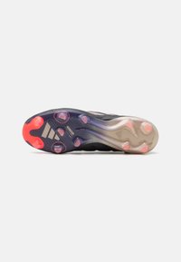 Suola di scarpa sportiva nera con un pattern testurizzato, caratterizzata da elementi traslucidi. Accenti in rosa e viola vicino alle aree del tallone e della punta.