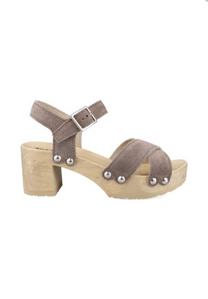 Beige Wildleder Open-Toe-Sandale mit Holzblockabsatz, verstellbarem Schnallenriemen und silbernen Nieten an den Riemen und der Sohlenkante.