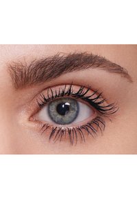 Gros plan sur un œil humain avec un iris bleu clair, des cils noirs bien marqués et un sourcil foncé bien défini. Texture de peau douce autour de l'œil.