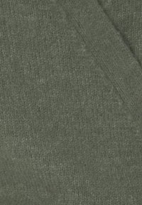 Tessuto verde testurizzato con una morbida e spessa trama, che presenta un motivo coerente e lievi variazioni di tonalità in tutto il materiale.
