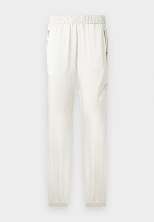 Világos krémszínű joggerek rugalmas derékrésszel, szűkítő mandzsettákkal, oldzsebekkel és cipzáros részletekkel. Simább, enyhén fényes szövetfelület.