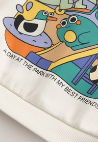Pájaro de dibujos animados con sombrero amarillo y rana con mejillas naranjas sentados juntos, con texto "A day at the park with my best friends."