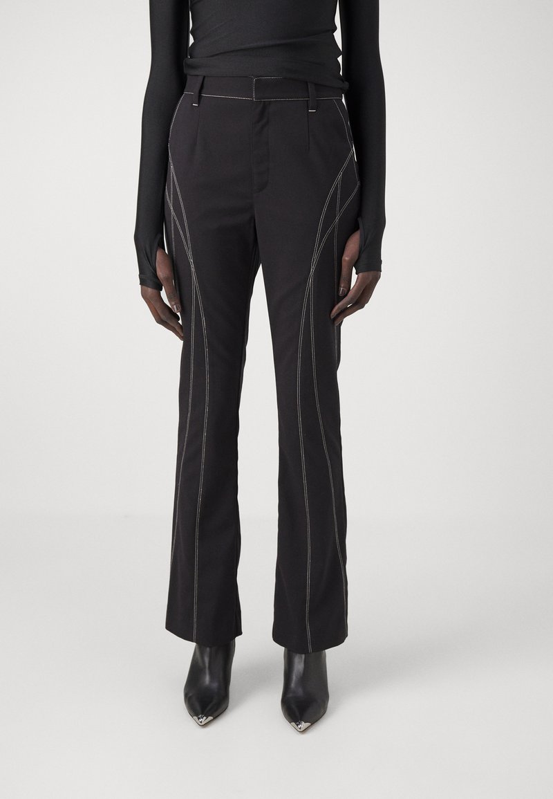 Pantalons noirs avec des coutures blanches contrastées, design à jambe droite et taille haute. Comprend des poches latérales et une texture lisse.