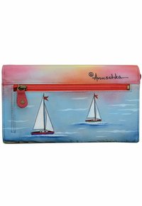 Kleurige portemonnee met zeilbootontwerpen op een blauwe achtergrond. Het materiaal lijkt leer te zijn met een ritssluiting en een grafisch zonsondergang effect.