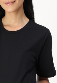 T-shirt in cotone nero con scollatura rotonda classica e maniche corte. Tessuto liscio, design aderente e senza pattern o accenti visibili.