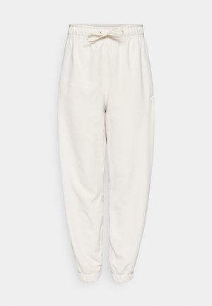 Pantalons de survêtement blancs avec une taille élastique et un cordon de serrage réglable. Design à jambes fuselées, texture douce, silhouette simple et minimalisme en matière de branding.