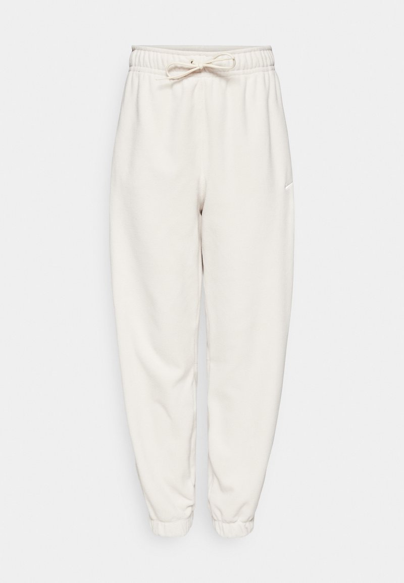Białe spodnie dresowe z elastycznym pasem i regulowanym sznurkiem. Zwężany krój nogawki, miękka tekstura, prosta sylwetka i minimalna marka.